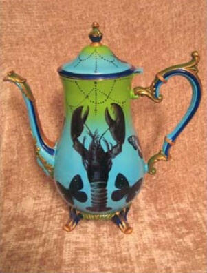 A whimsical aqua fading to green teapot with a long curved spout and decorative handle, adorned with a large lobster and butterflies, and hand painted details
