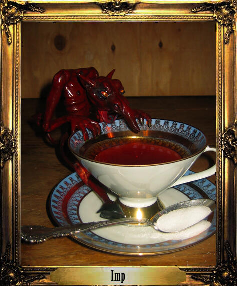 A tiny jointed resin doll of a devilish imp in dark red with a forked tongue lapse tea out of a vintage teacup larger than himself